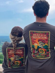 guests enjoying the view at dirt farm brewing wearing their dead on the mountain tee shirts