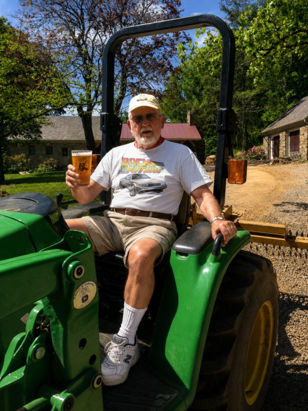 Paw Paw sitting on a tractor drinking a cold beer on Father's Day at Dirt Farm brewing