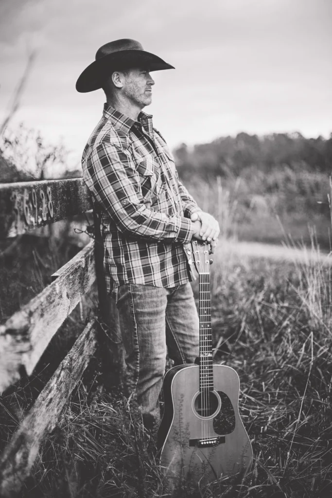 mark Cullinane, local musician, leaning up against a fence to play live music at Dirt Farm Brewing in Loudoun County virginia