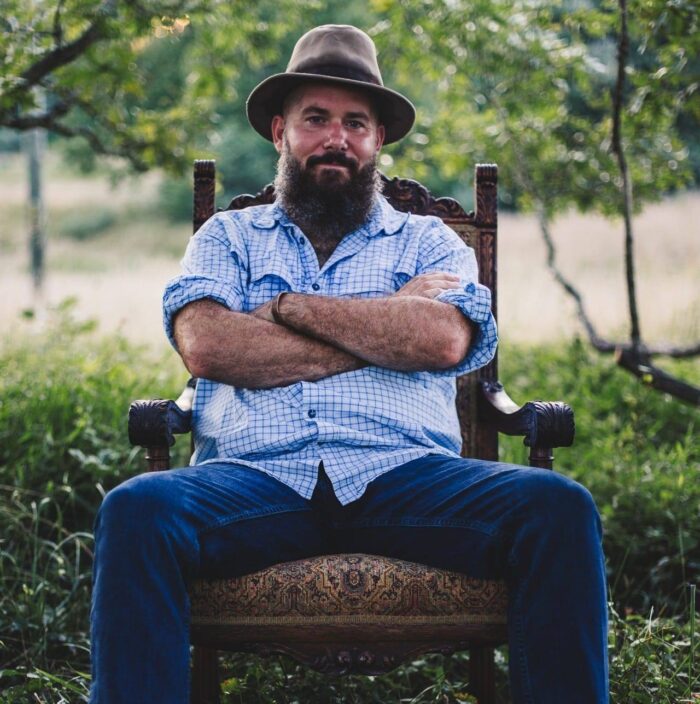 Live Music feat. Luke Johnson, Luke poses in a chair at Dirt Farm brewing