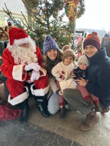 Santa Claus taking a photo with happy guests at dirt farm brewing christmas tree lighting event in Loudoun county