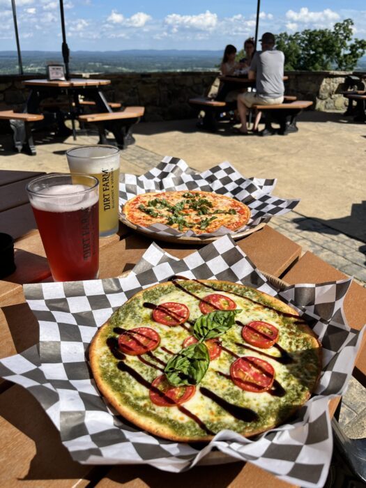 A table covered in beer and pizzas at Dirt farm Brewing during happy hour in Loudoun county virginia