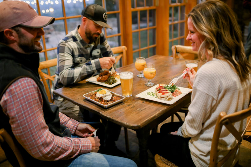 Guests enjoying the rise and climb Sunday brunch at dirt farm brewing with plates full of chicken and donuts