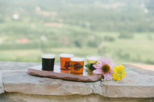 Flight of four beers displayed outside with panoramic views at Dirt Farm brewing in loudoun county virginia