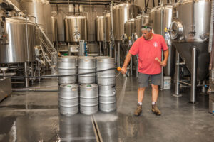 Bruce Zurschmeide hosing off the floor in the brew house at dirt farm Brewing in Loudoun county